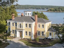 Yellow waterfront residence with circular driveway and waterview