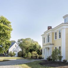 Yellow waterfront residence with old barn in background