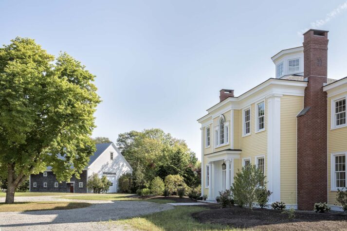 Yellow waterfront residence with old barn in background