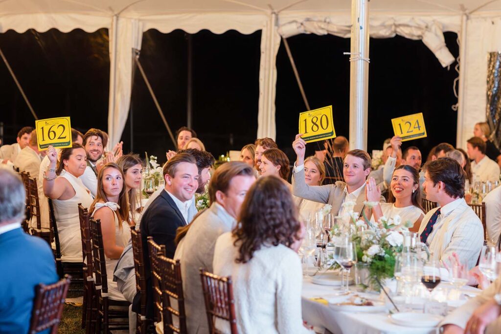 Benefit attendees place bids during the Paddle Raise for the Carroll Homestead.