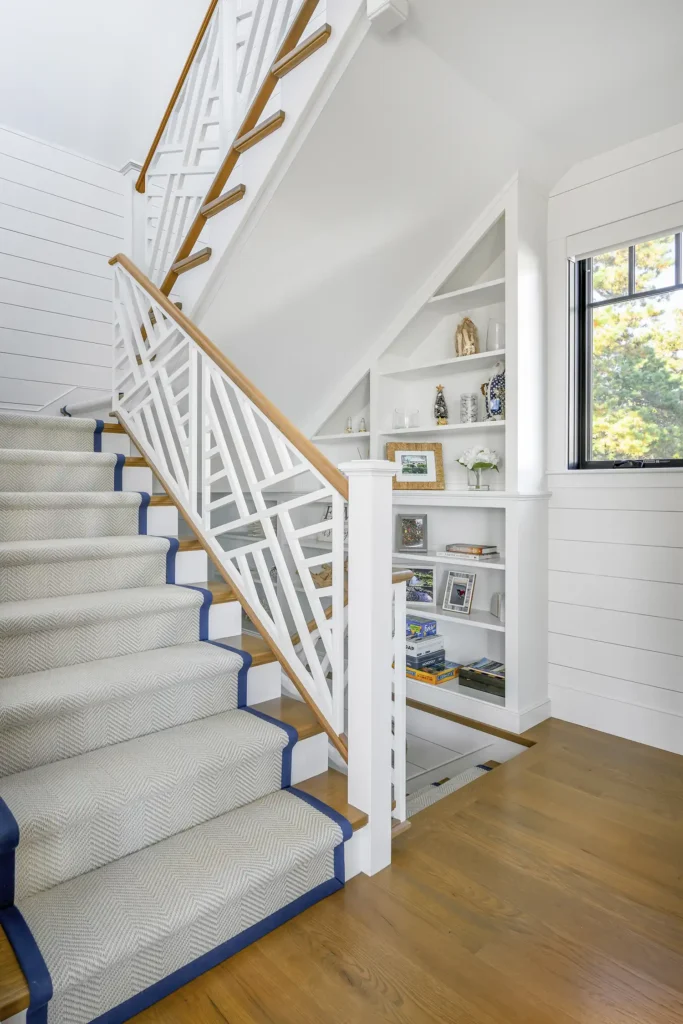 A Fibreworks wool runner cascades down stairs next to a railing designed by Blakely Interior Design.
